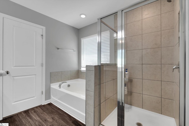 bathroom featuring wood-type flooring and separate shower and tub