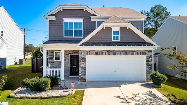 craftsman-style house with a front yard, central air condition unit, and a garage