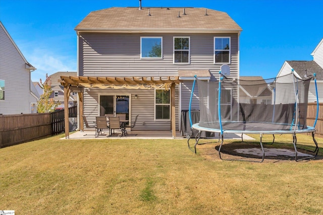 back of property featuring a patio, a trampoline, and a yard