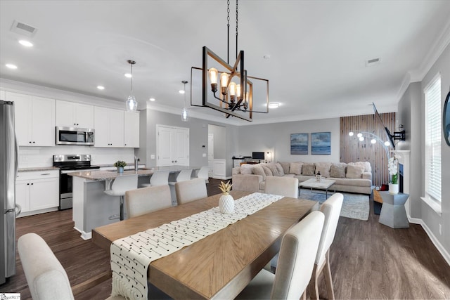 dining area featuring sink, crown molding, dark wood-type flooring, and plenty of natural light