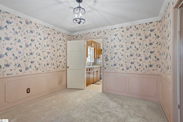 unfurnished bedroom featuring ensuite bathroom, light carpet, crown molding, and an inviting chandelier