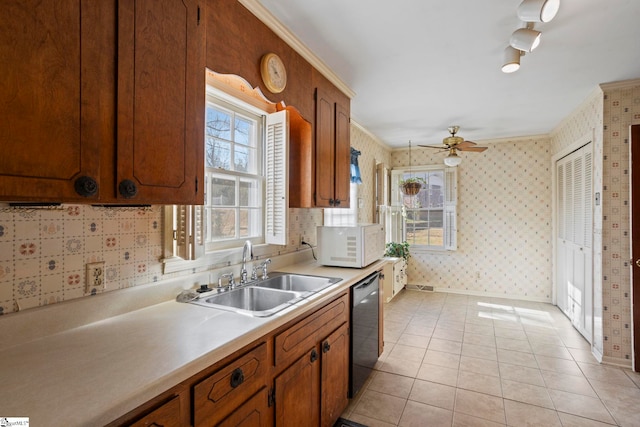 kitchen featuring dishwasher, sink, ceiling fan, light tile patterned floors, and crown molding