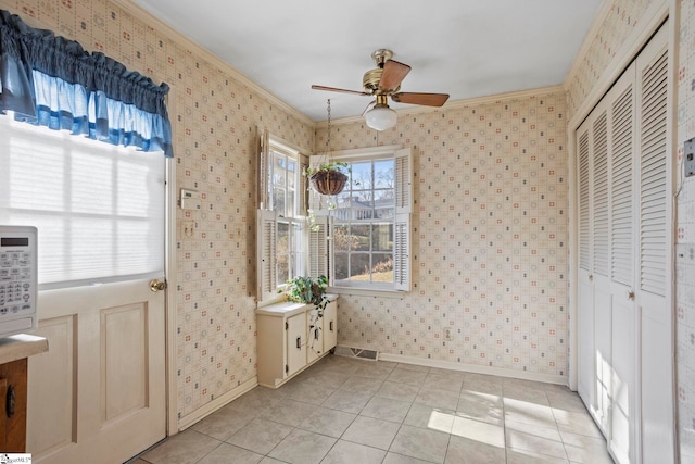 interior space with ceiling fan, crown molding, and light tile patterned flooring