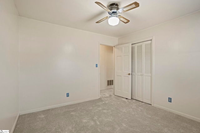 unfurnished bedroom with a closet, ceiling fan, and light colored carpet