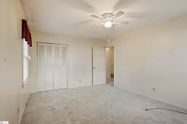 unfurnished bedroom with ceiling fan, a closet, and light carpet