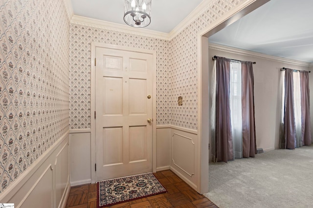 foyer entrance featuring ornamental molding, parquet floors, and an inviting chandelier