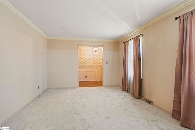 carpeted spare room featuring crown molding