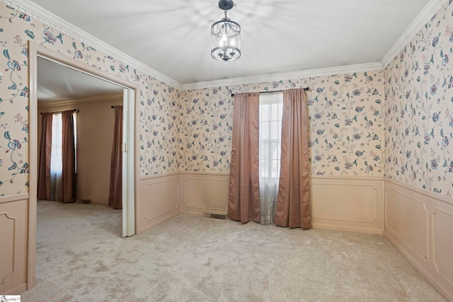 empty room featuring a notable chandelier, light colored carpet, and ornamental molding