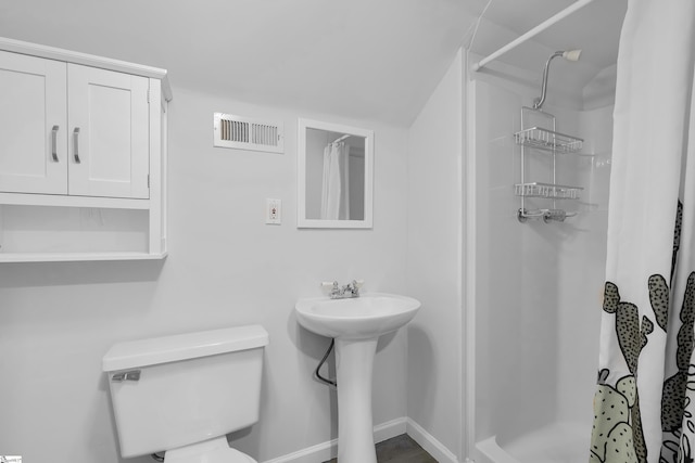 bathroom featuring sink, toilet, and a shower with curtain