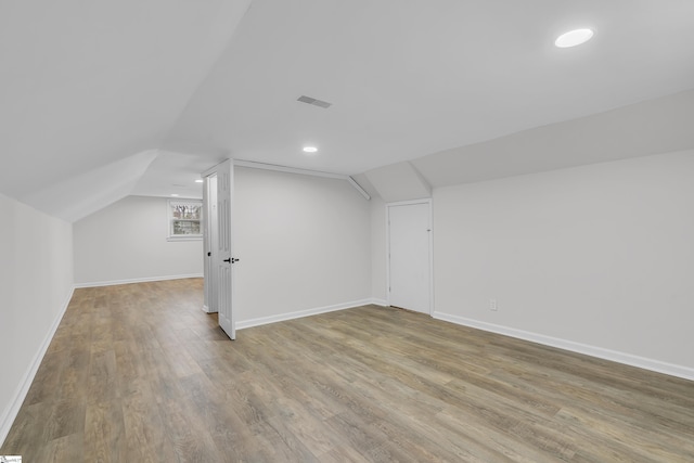 additional living space featuring hardwood / wood-style flooring and vaulted ceiling