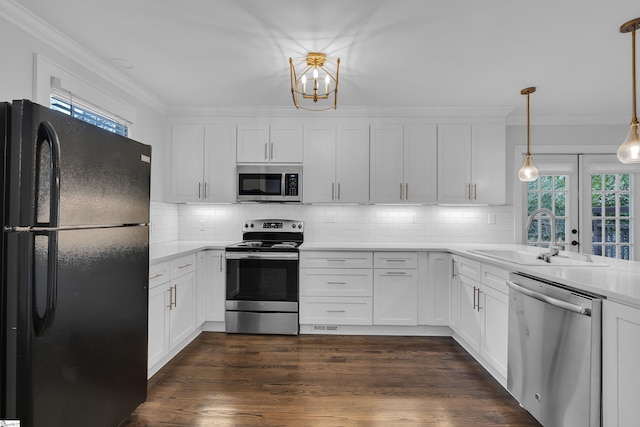 kitchen featuring decorative light fixtures, white cabinetry, stainless steel appliances, sink, and backsplash