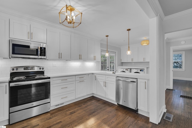 kitchen featuring hanging light fixtures, appliances with stainless steel finishes, sink, backsplash, and white cabinetry