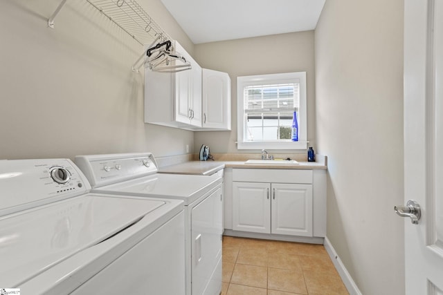 laundry area with sink, light tile patterned floors, cabinets, and washer and dryer