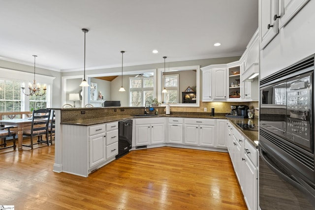 kitchen with black appliances, white cabinetry, sink, hanging light fixtures, and kitchen peninsula