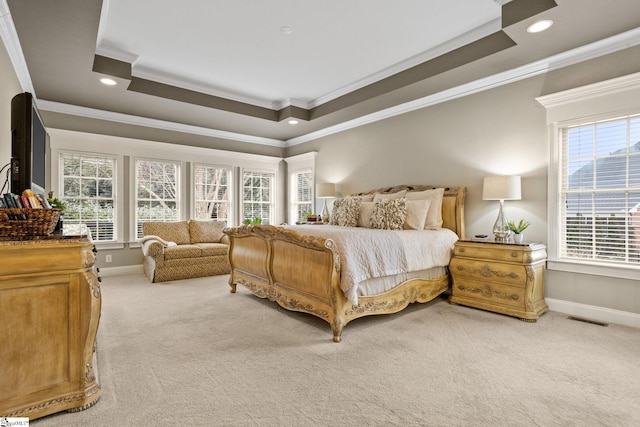 bedroom featuring light colored carpet, a tray ceiling, and ornamental molding