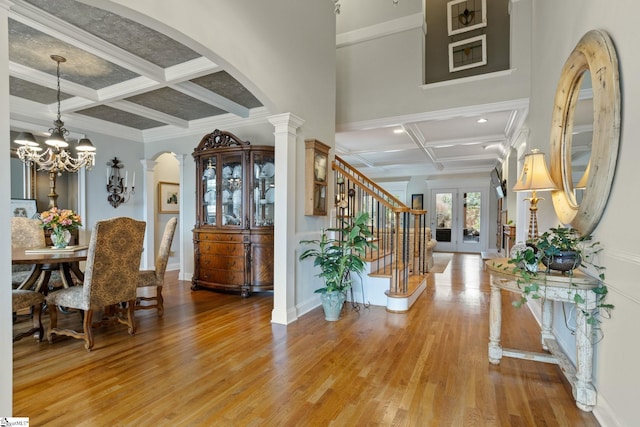 entrance foyer featuring decorative columns, hardwood / wood-style flooring, beam ceiling, and coffered ceiling