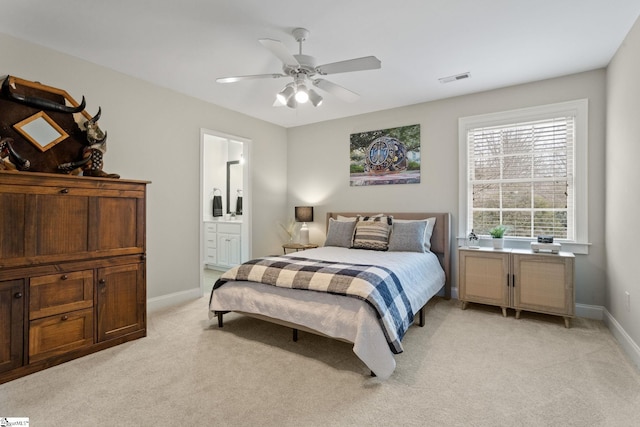 carpeted bedroom with ceiling fan and ensuite bath