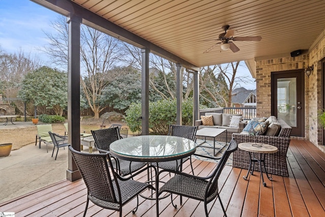 wooden terrace featuring ceiling fan, outdoor lounge area, and a patio