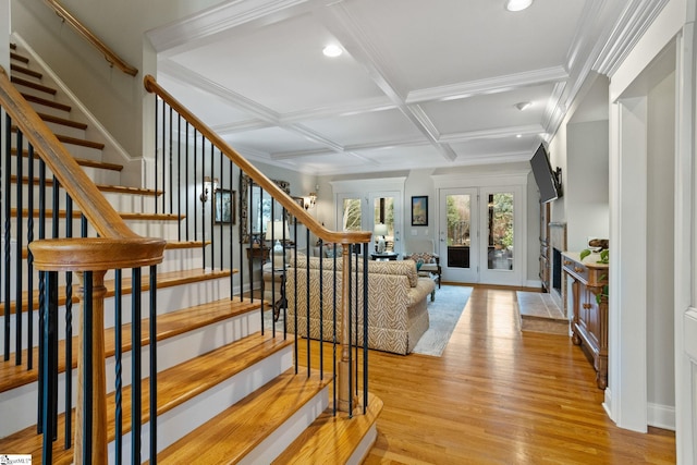 stairs featuring hardwood / wood-style floors, beamed ceiling, french doors, ornamental molding, and coffered ceiling