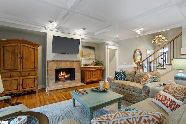 living room with hardwood / wood-style floors, beamed ceiling, a fireplace, ornamental molding, and coffered ceiling