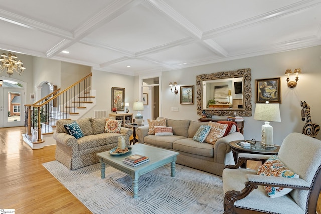 living room with coffered ceiling, light wood-type flooring, a chandelier, and beam ceiling