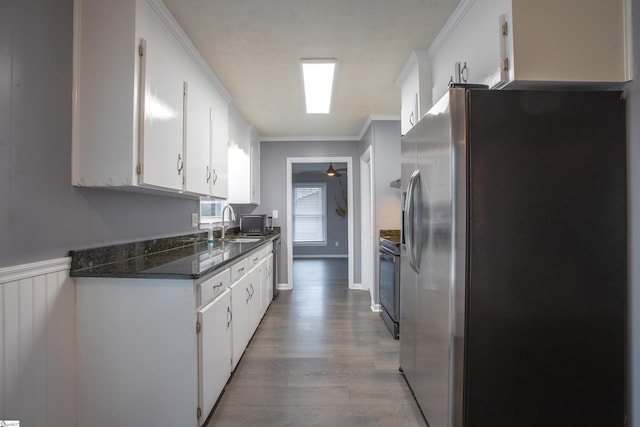 kitchen with ceiling fan, white cabinetry, light hardwood / wood-style flooring, ornamental molding, and stainless steel appliances