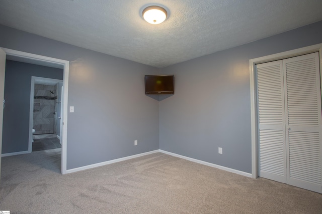 unfurnished bedroom featuring a closet, carpet flooring, and a textured ceiling