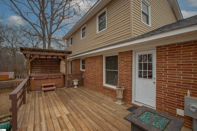 wooden deck with a fire pit, a pergola, and a hot tub