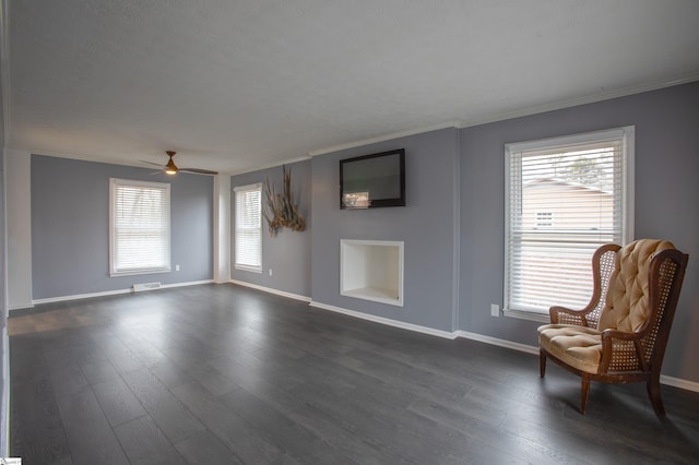 sitting room with crown molding, built in features, ceiling fan, and dark hardwood / wood-style flooring