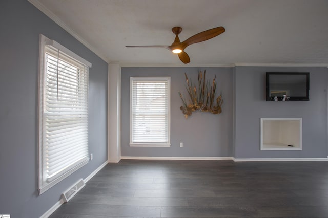 empty room featuring ceiling fan, ornamental molding, and dark hardwood / wood-style floors