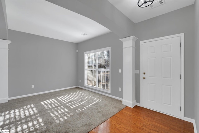 foyer featuring hardwood / wood-style floors and decorative columns