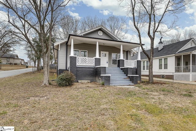 view of front of home with a porch and a front lawn