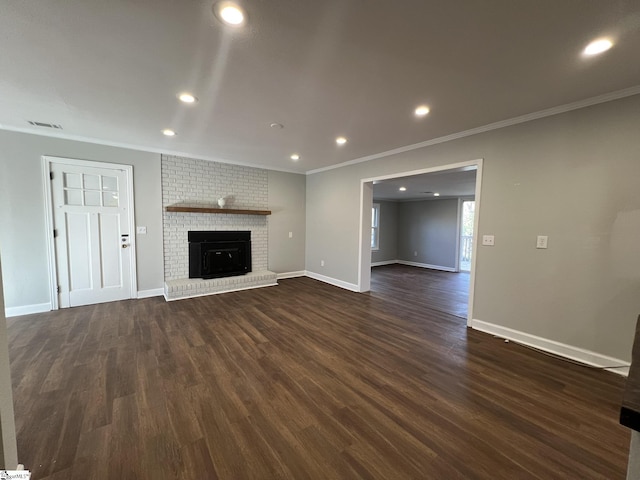 unfurnished living room featuring a brick fireplace, crown molding, and dark hardwood / wood-style floors