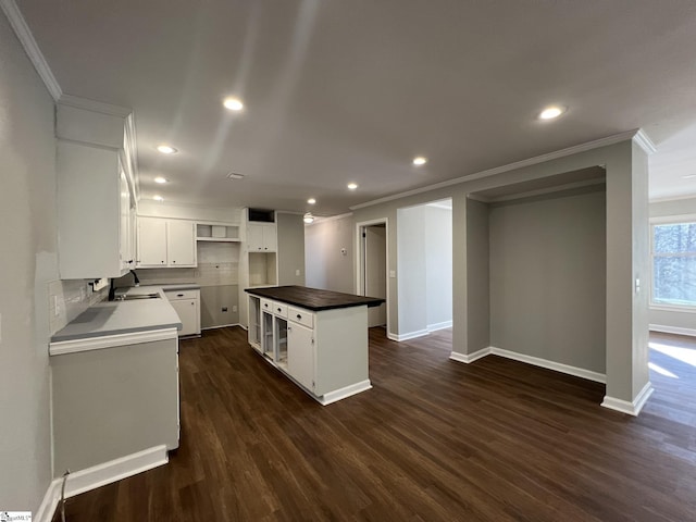 kitchen featuring white cabinets, a kitchen island, decorative backsplash, sink, and dark hardwood / wood-style floors