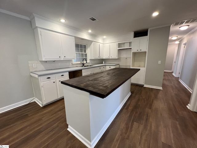 kitchen with a kitchen island, white cabinets, dark hardwood / wood-style floors, and sink