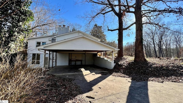 back of house featuring a carport