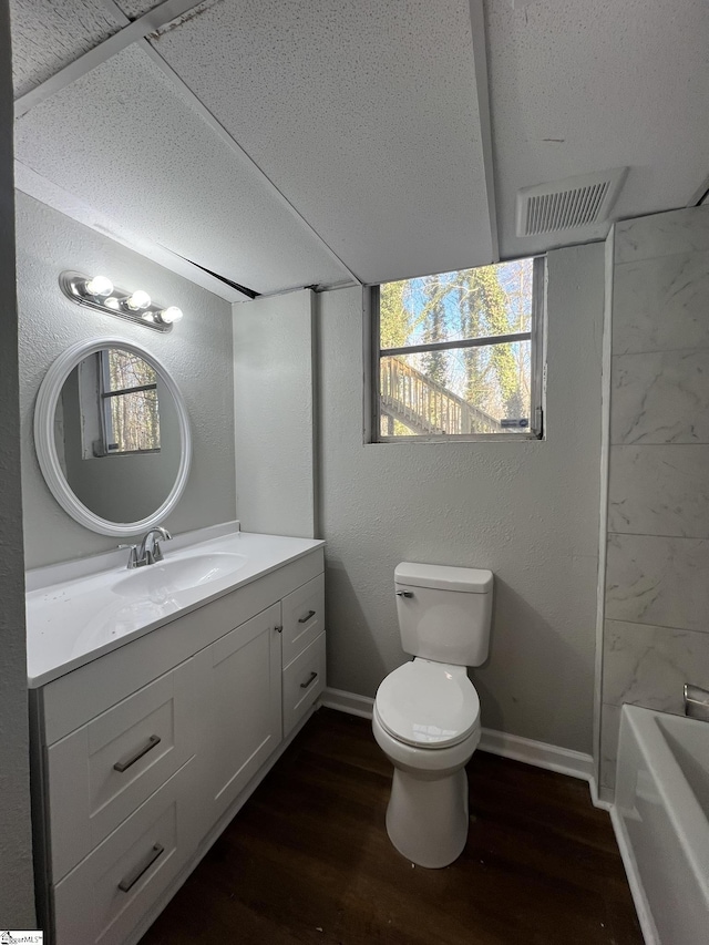 bathroom with hardwood / wood-style flooring, a wealth of natural light, toilet, and vanity