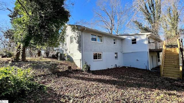 rear view of house with central AC unit and a wooden deck