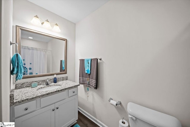 bathroom featuring vanity, toilet, a shower with shower curtain, and hardwood / wood-style flooring