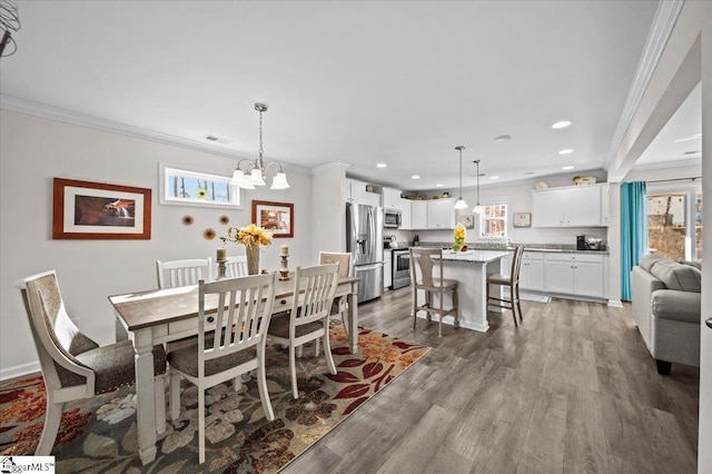 dining room featuring dark hardwood / wood-style flooring, a notable chandelier, and ornamental molding