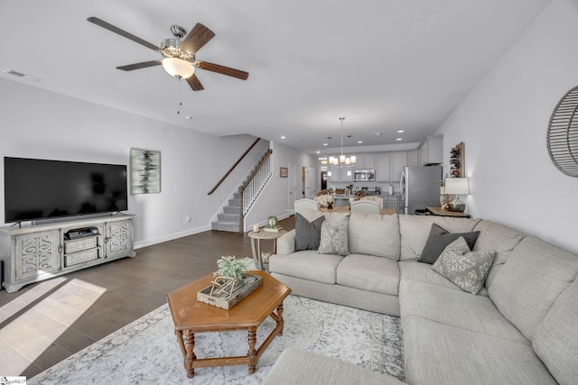 living room featuring hardwood / wood-style flooring and ceiling fan with notable chandelier