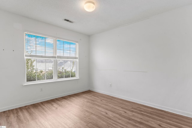 unfurnished room featuring hardwood / wood-style floors and a textured ceiling