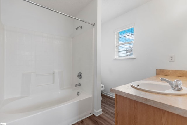 full bathroom with toilet, a textured ceiling, hardwood / wood-style flooring, vanity, and  shower combination