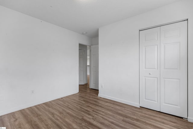 unfurnished bedroom featuring a closet and light wood-type flooring