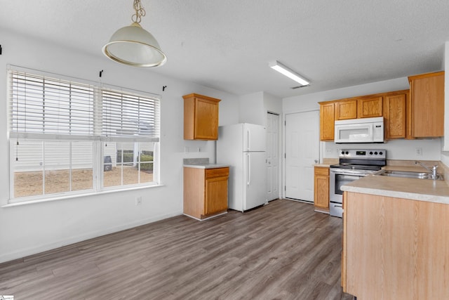 kitchen featuring white appliances, a textured ceiling, hardwood / wood-style flooring, sink, and decorative light fixtures