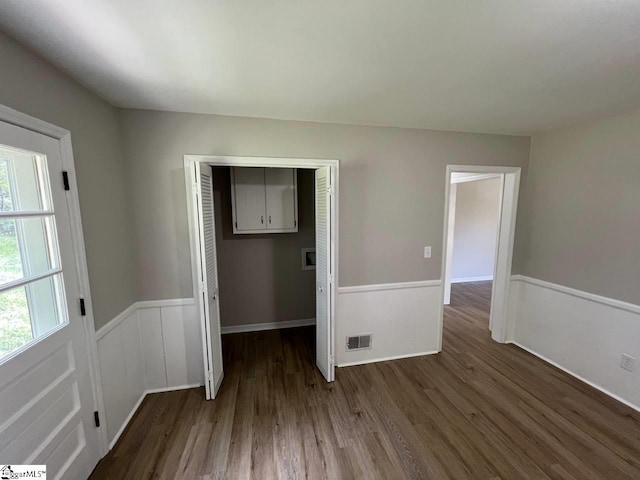 empty room with dark wood-type flooring and plenty of natural light