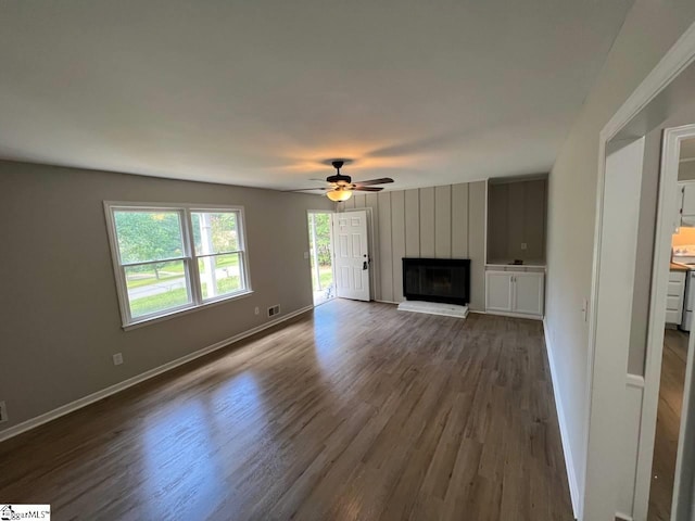 unfurnished living room with a fireplace, hardwood / wood-style flooring, and ceiling fan