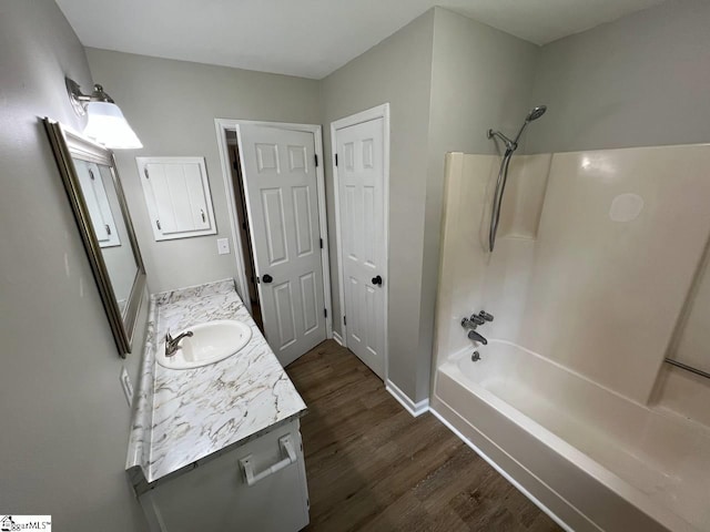 bathroom with wood-type flooring, vanity, and  shower combination