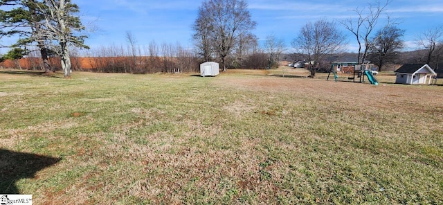 view of yard with a playground and a shed