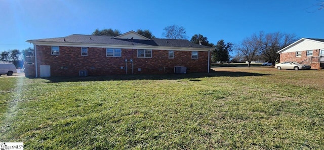 back of house featuring a lawn and central AC